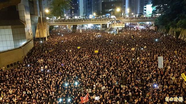 16日香港反送中大遊行入夜後人潮依舊擠滿整條街道。(記者簡惠茹攝)