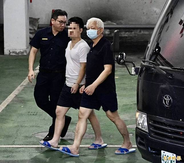 台北地檢署偵辦前民進黨黨工涉共諜案10日偵查終結起訴黃取榮、吳尚雨、邱世元、何仁傑。在押的黃取榮(右)步下囚車移審台北地方法院。(記者羅沛德攝)