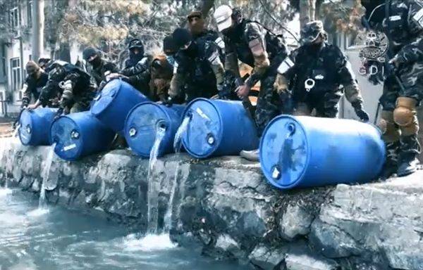 塔利班士兵將喀布爾突擊行動中查扣的數桶儲酒倒入運河中。   圖：翻攝推特