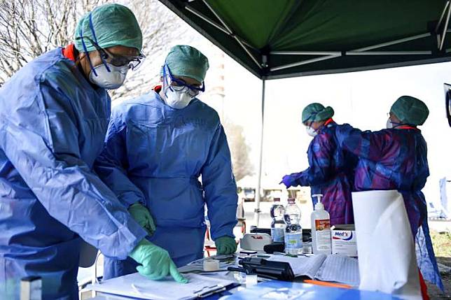 義大利北部城市布雷西亞（Brescia）的醫護人員正在臨時搭建的急診處工作。（美聯社）
