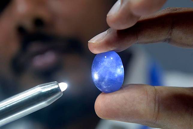 A man checks a gemstone on display during FACETS Sri Lanka 2025, an international gem and jewellery exhibition, in Colombo, Sri Lanka, Jan. 4, 2025. (Photo by Gayan Sameera/Xinhua)