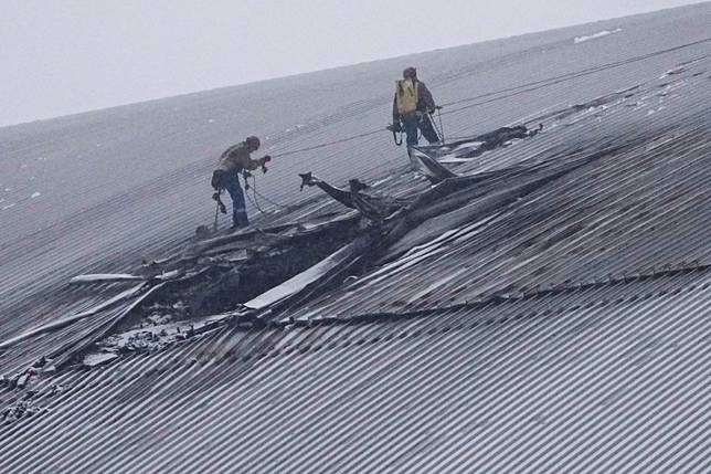 2025年2月14日，烏克蘭車諾比核電廠屋頂，工人在覆蓋於爆炸的4號反應爐上方的防護罩，檢查防護罩遭無人機攻擊後的受損情況，烏方稱此為俄軍的攻擊。美聯社