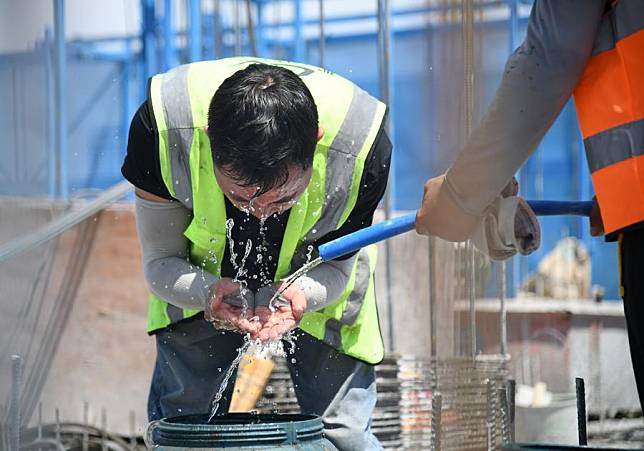 An outdoor worker washes his face at a construction site in Xi'an, northwest China's Shaanxi Province, June 13, 2024. (Xinhua/Zhang Bowen)