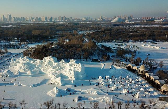 An aerial drone photo taken on Jan. 7, 2024 shows contestants working on snow sculptures during the international snow sculpture competition at the Sun Island scenic area in Harbin, northeast China's Heilongjiang Province. (Xinhua/Wang Jianwei)