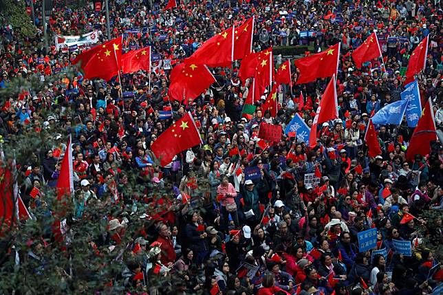 Pro-Beijing supporters wave Chinese national flags at the rally in Harbour Road Garden. Photo: Reuters
