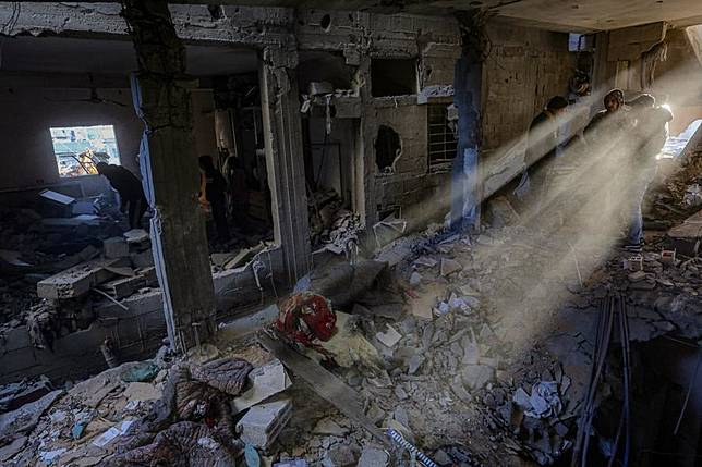 People are seen inside a building destroyed in an Israeli airstrike in al-Nuseirat refugee camp, central Gaza Strip, on Dec. 16, 2024. (Photo by Rizek Abdeljawad/Xinhua)