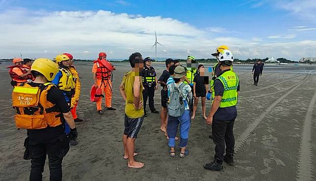 台中市大安區海水浴場濱海樂園二十三日一名帶隊男老師，帶著七名學生到海水浴場進行戶外教學，結果受困沙洲，消防隊獲報後趕抵現場，救出七名學生。（記者陳金龍翻攝）