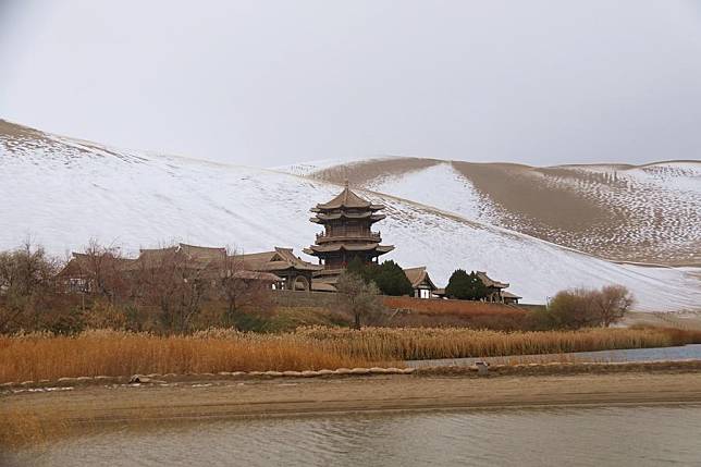 This photo taken on Nov. 23, 2024 shows snow scenery of the Mingsha Mountain and Crescent Spring scenic spot in Dunhuang, northwest China's Gansu Province. (Photo by Zhang Xiaoliang/Xinhua)