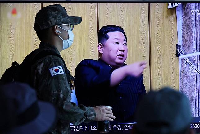 北韓爆發COVID-19疫情。圖為韓國首爾火車站，一名士兵走過播放有關北韓疫情新聞報導的電視畫面。 （路透）