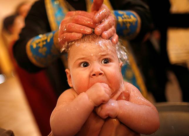 在天主教的信仰中，受洗儀式是一種聖禮，儀式中澆到人們額頭上的聖水象徵著淨化和進入教會。（圖片非當事人） 路透社 / 達志影像