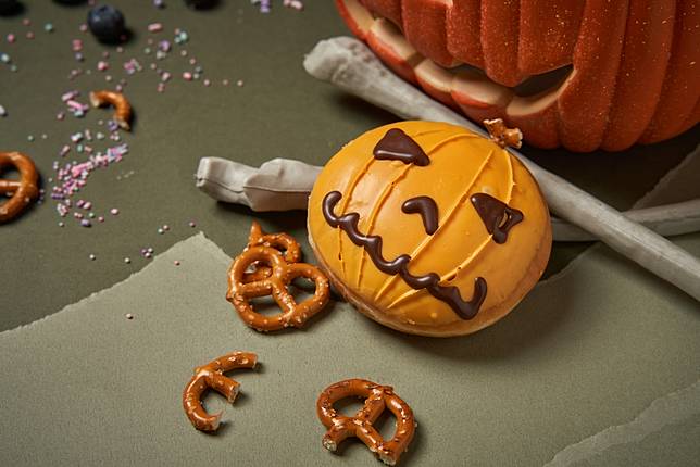 「傑克南瓜」甜甜圈，滑順的南瓜卡士達內餡，淋上滿滿南瓜巧克力，頭上還插著酥脆蝴蝶餅，造型可愛又俏皮！(圖片提供/Krispy Kreme)