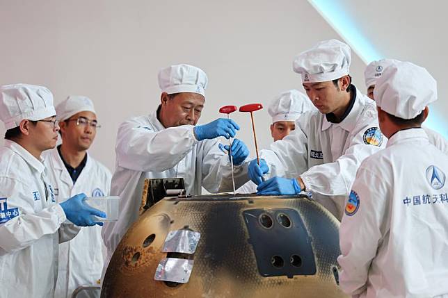 The returner of the Chang'e-6 lunar probe is opened during a ceremony at the China Academy of Space Technology under the China Aerospace Science and Technology Corporation in Beijing, capital of China, June 26, 2024. (Xinhua/Jin Liwang)