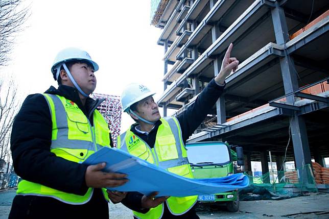 Zhou Pei &reg; instructs workers at a construction site in Cangzhou, north China's Hebei Province, Feb. 15, 2025. (Photo by Yin Shi/Xinhua)