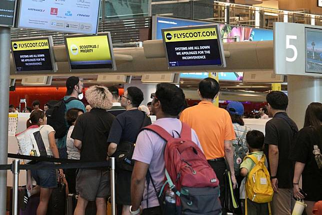 Passengers queue at check-in counters in Singapore's Changi Airport on July 19, 2024. A faulty software update from cybersecurity firm CrowdStrike on July 19, 2024 affected computers running Microsoft Windows at organizations, causing major IT outage, taking out banks, airlines and businesses globally. (Photo by Then Chih Wey/Xinhua)