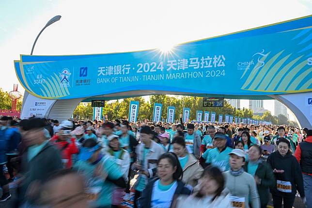 Participants set off from the starting line during the 2024 Tianjin Marathon on Oct. 20, 2024. (Xinhua/Sun Fanyue)