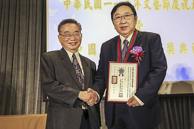 李德莊領獎之後手握著中國文藝獎章證書，與中國文藝協會理事長王吉隆合影。