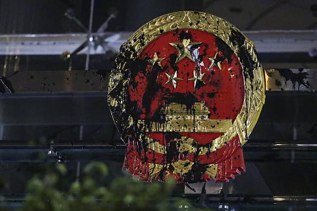 China’s national emblem was defaced by protesters outside the liaison office in Sai Ying Pun on Sunday. Photo: Edmond So