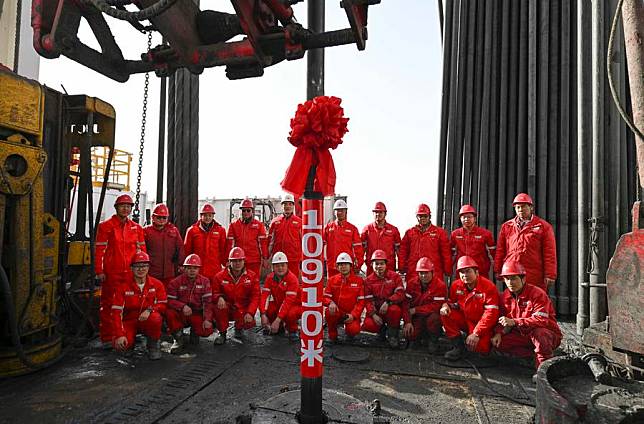 Staff members pose for a group photo as they celebrate the completion of the drilling of &ldquo;Shenditake 1,&rdquo; an ultra-deep borehole reaching 10,910 meters, in the hinterland of the Taklimakan Desert in the Tarim Basin, northwest China's Xinjiang Uygur Autonomous Region, Feb. 20, 2025. (Xinhua/Hu Huhu)