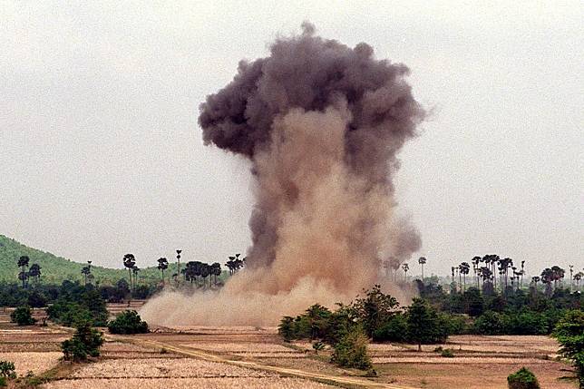 A cloud of dust and smoke rises into the sky as deminers from the Cambodian Mine Action Centre, with the help of non-governmental organisation Halo Trust, explode landmines in the western province of Kampong Speu, Cambodia. Photo: AFP