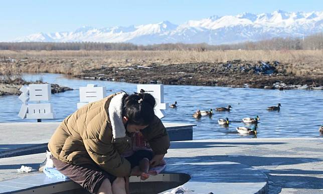 Kulmkhan Bagatur and her daughter soak their feet in the soothing warmth of a natural hot spring in Wenquan County, northwest China's Xinjiang Uygur Autonomous Region, Nov. 28, 2024. (Xinhua/Zhang Xiaolong)