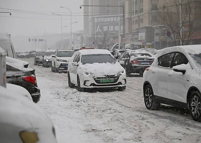 遼寧市民冒着大雪開車出行。（中新社圖片）