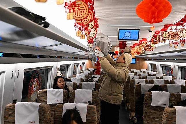 A passenger puts the luggage in place on the bullet train G4798 on the Jining-Datong-Yuanping high-speed railway, Dec. 31, 2024. (Xinhua/Li Zhipeng)