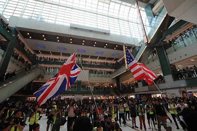Protesters in New Town Plaza in Sha Tin wave the British and US flags. Photo: Felix Wong