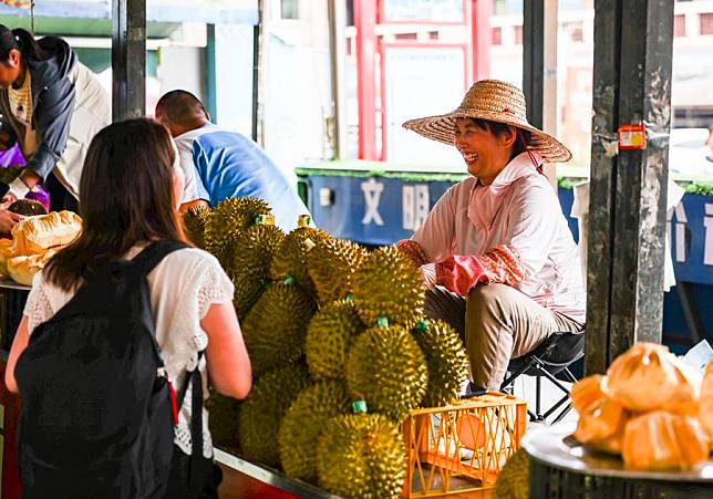 Vietnamese vendors sell durians in Dongxing, south China's Guangxi Zhuang Autonomous Region, on May 18, 2023. (Xinhua/Hu Xingyu)