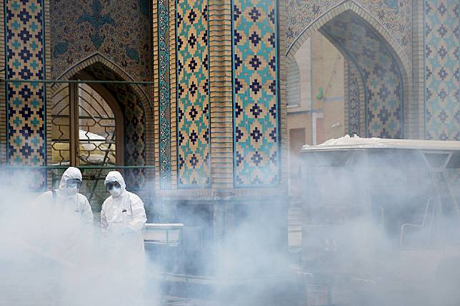 圖為伊朗兩名防疫人員準備為伊瑪目禮薩聖陵(Imam Reza's holy shrine)消毒防疫。在兩個禮拜以前，伊朗尚能宣稱疫情對他們「不成問題」。 路透社/達志影像