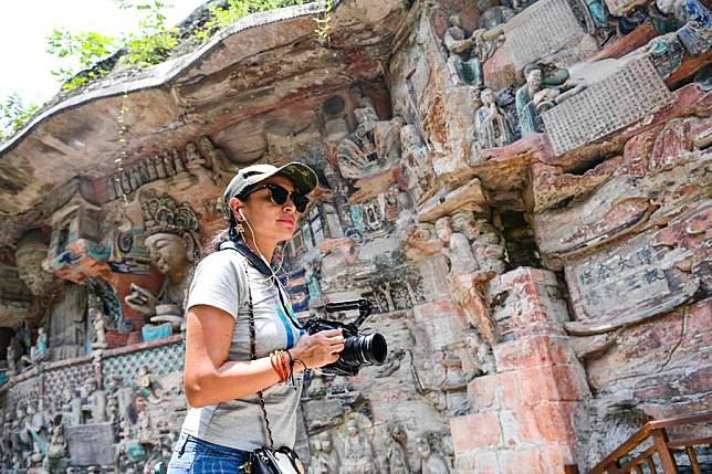 A tourist from abroad visits the scenic spot of Dazu Rock Carvings in southwest China's Chongqing, July 19, 2024. (Xinhua/Wang Quanchao)