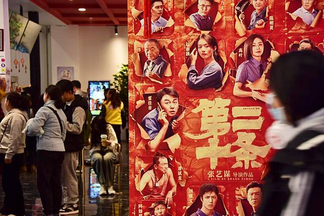 A citizen walks past a movie poster at a cinema in Gejiu City, southwest China's Yunnan Province, Feb. 15, 2024. (Photo by Xue Yingying/Xinhua)