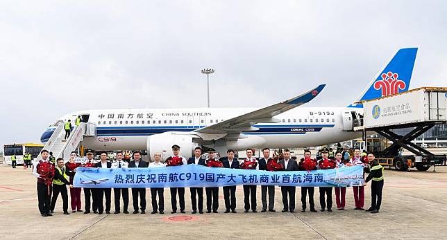 Guests and crew members pose for photos in front of the C919 aircraft at a welcoming ceremony on the tarmac of Haikou Meilan International Airport in Haikou, south China's Hainan Province, on Dec. 11, 2024. (Xinhua/Yang Guanyu)