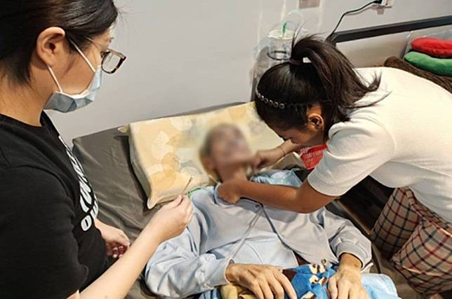 外籍看護工演練鼻胃管清潔技巧實作。(台北市勞動局提供)