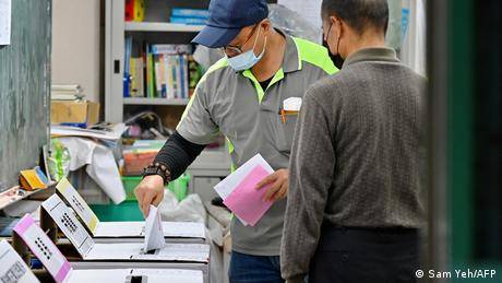 圖為台灣一名男子在2022年11月26日新北市市長選舉投票期間在投票站投下選票的畫面。