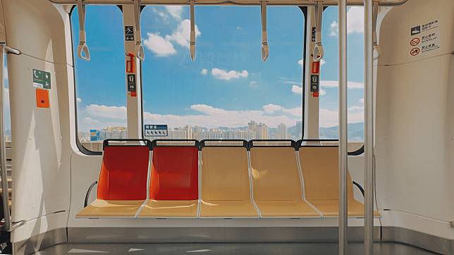 安坑輕軌使用大型側窗，當車廂移動時，窗外美景搭配紅黃座位顯得更加活潑可愛，宛如置身日本。（鏡新聞）