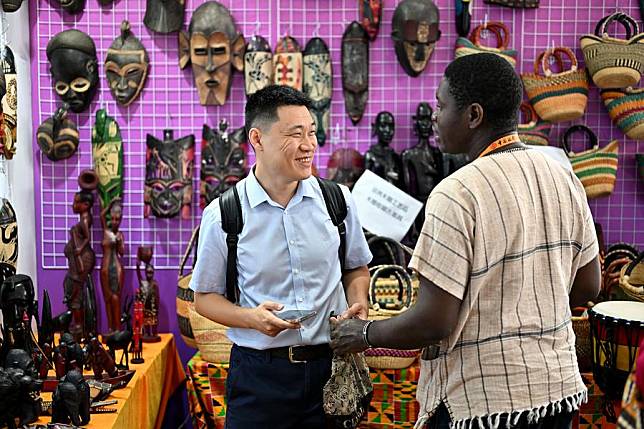 A visitor buys handicrafts at the booth of Uganda at the exhibition area of culture & tourism services during the 2023 China International Fair for Trade in Services (CIFTIS) in Beijing, capital of China, Sept. 6, 2023. (Xinhua/Li Xin)