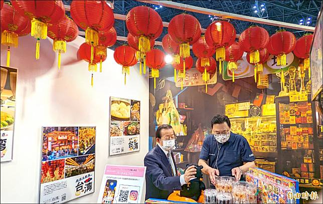 東京旅展台灣館今年的設計充滿台灣古早味，駐日代表謝長廷與華航東京分公司總經理張鴻鐘也忍不住把玩。(記者林翠儀攝)