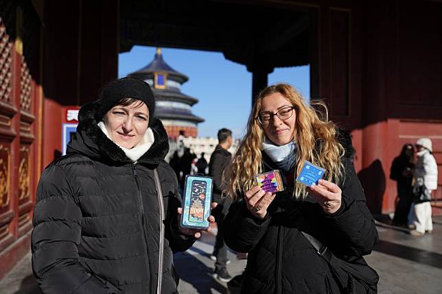 Tourists from Hungary show souvenirs bought at Tiantan (Temple of Heaven) Park in Beijing, capital of China, Dec. 5, 2024. (Xinhua/Ju Huanzong)