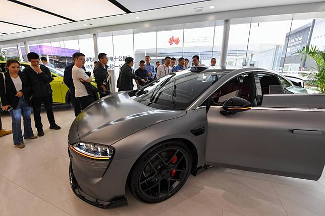 Visitors watch a new energy vehicle equipped with Huawei's Qiankun system at the 2024 Beijing International Automotive Exhibition in Beijing, China, April 25, 2024. (Xinhua/Ju Huanzong)