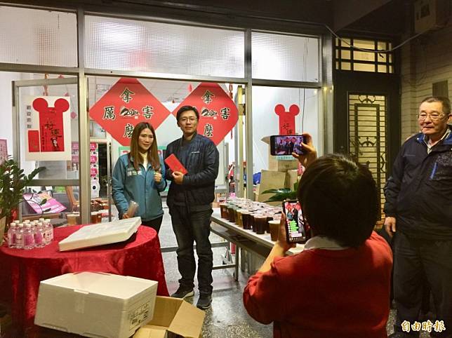 台北市議員(左)陳怡君今晚幫網路紅人「小商人」發雞排，吸引數以百計的民眾排隊。後方貼著是「小商人」新印製的「拿麼厲害」春聯。(記者陳璟民攝)