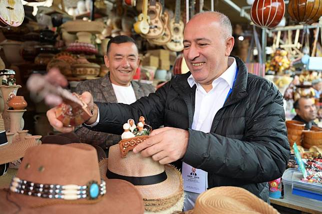 Attendees of the 6th World Media Summit select souvenirs in the ancient city of Kashgar, northwest China's Xinjiang Uygur Autonomous Region, Oct. 16, 2024. (Xinhua/Wang Yijie)