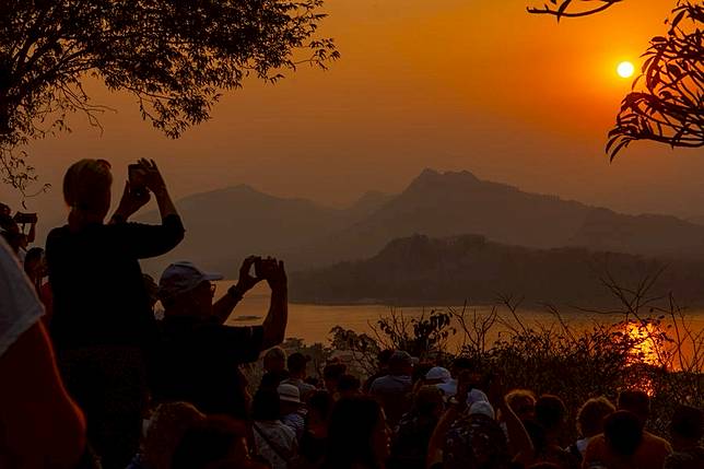Travelers enjoy the sunset from Phou si Mountain at Luang Prabang, Laos, on Feb. 16, 2025. (Photo by Kaikeo Saiyasane/Xinhua)