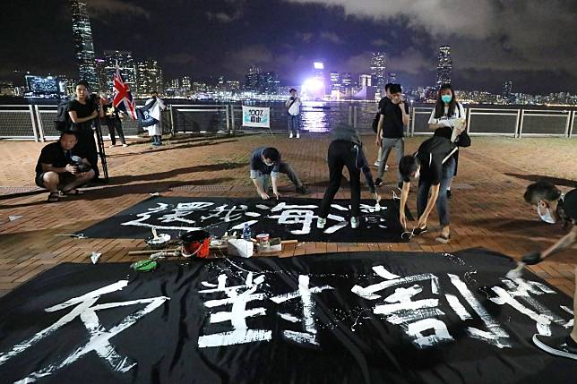 Protesters paint banners to oppose the handover of the Central harbourfront to the PLA. The banners read: ‘Return the waterfront to us! Against this cessation of land.’ Photo: Dickson Lee