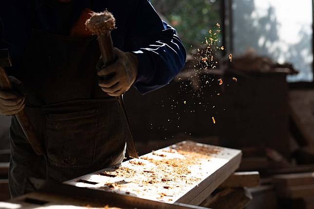 A worker carves a piece of lumber for the construction of Hui-style building in ancient style at a company in Huangshan, east China's Anhui Province, Jan. 6, 2025. (Xinhua/Zhang Duan)