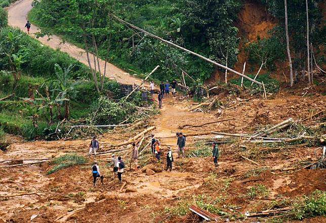 Villagers walk on the muddy area near the site of a landslide in Kasimpar Village of Pekalongan, Central Java, Indonesia, Jan. 22, 2025. (Photo by Kalila/Xinhua)