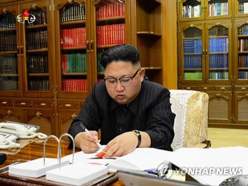  北韓領導人金正恩聽取攻打關島簡報，強調「已進入備戰狀態，隨時突發射擊」。但官媒報導也提到，金正恩會再觀察美國的行動一陣子，暗示他將推遲(hold off)對關島試射導彈計劃。   圖：翻攝自韓聯社網站 