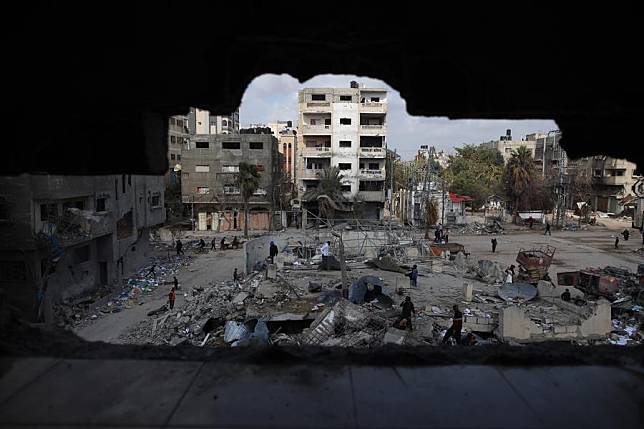 People are framed by the structure of a damaged building at Bureij refugee camp in the central Gaza Strip, March 19, 2024. (Xinhua)