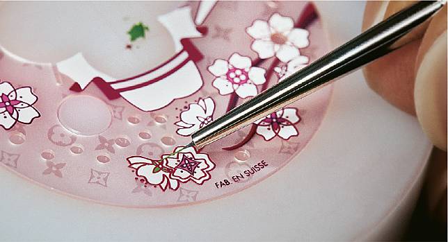 手繪微型櫻花–Sakura版腕表上，工匠以沙粉打磨出對比鮮明的半透明monogram圖案，並親手繪畫微型櫻花和樹枝。表盤上的Fab. en Suisse代表腕表在瑞士製造。（品牌提供）
