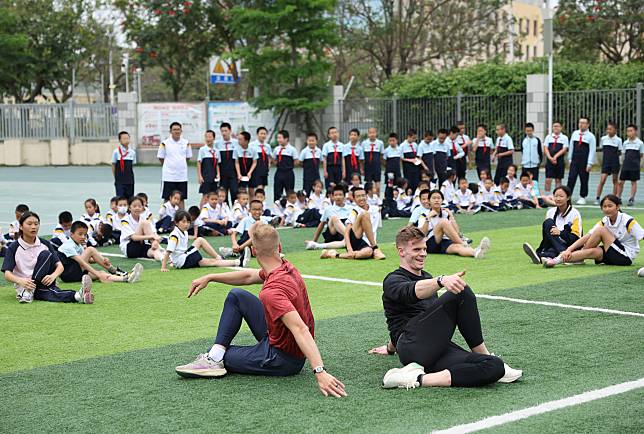 Pole vaulters Sam Kendricks (front L) and Chris Nilsen (front R) of the United States interact with local students during a pre-event school visit activity before the 2024 Wanda Diamond League Xiamen Meeting in Xiamen, southeast China's Fujian Province, April 18, 2024. (Xinhua/Li Ming)