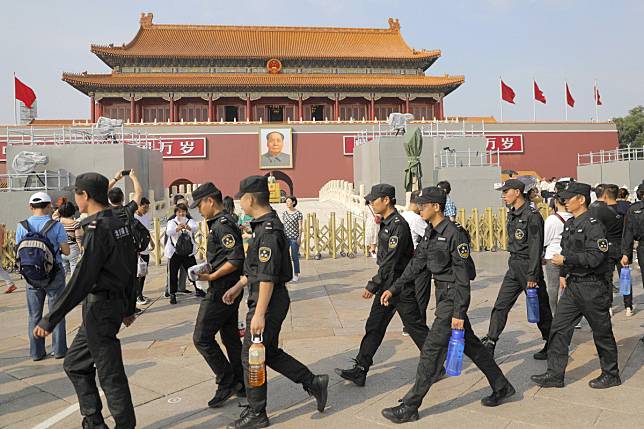 Security officers walk past the Tiananmen Gate in Beijing on Tuesday. Security is tight ahead of a huge military parade on October 1. Photo: EPA-EFE